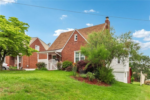 1027 Goldenrod St, Homestead, PA 15120 - tudor-style house featuring a chimney, a front yard, and brick siding
