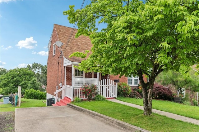 1027 Goldenrod St, Homestead, PA 15120 - view of front facade with brick siding, a front yard, and covered porch
