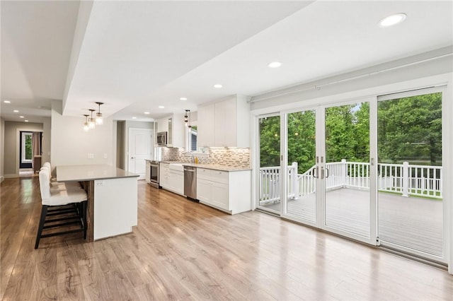 3442 Mercer Rd, Neshannock Twp, PA 16105 - kitchen with a breakfast bar, backsplash, white cabinetry, light wood-style flooring, and a chandelier
