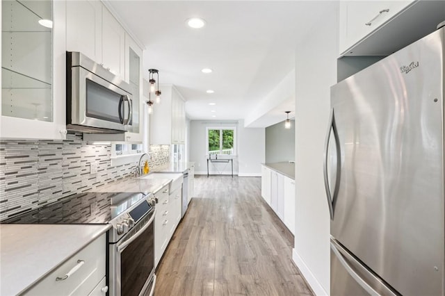 3442 Mercer Rd, Neshannock Twp, PA 16105 - kitchen with stainless steel appliances, white cabinetry, decorative backsplash, light wood-type flooring, and glass insert cabinets