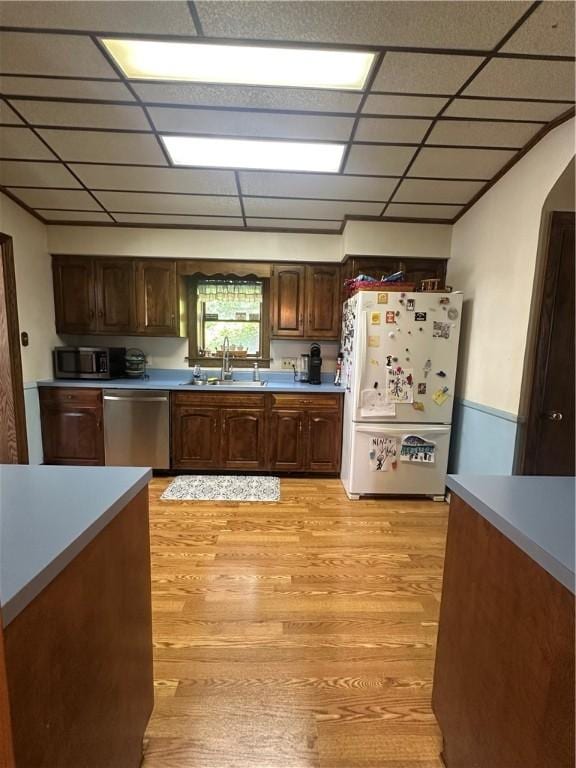 566 4th St, City Of But Ne, PA 16001 - kitchen with appliances with stainless steel finishes, light wood-type flooring, light countertops, a drop ceiling, and dark brown cabinets