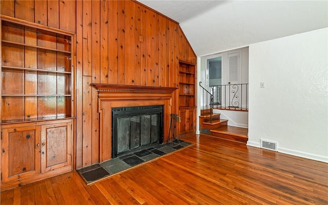 300 S Pasadena Dr, Fox Chapel, PA 15215 - unfurnished living room featuring wood finished floors, stairs, a fireplace, built in features, and wooden walls