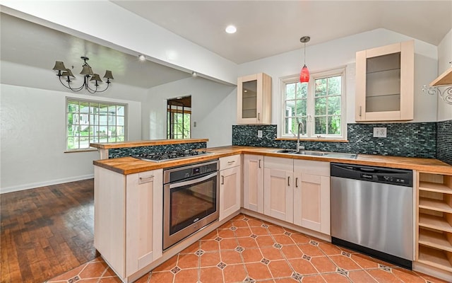300 S Pasadena Dr, Fox Chapel, PA 15215 - kitchen featuring appliances with stainless steel finishes, butcher block counters, a peninsula, tasteful backsplash, and recessed lighting