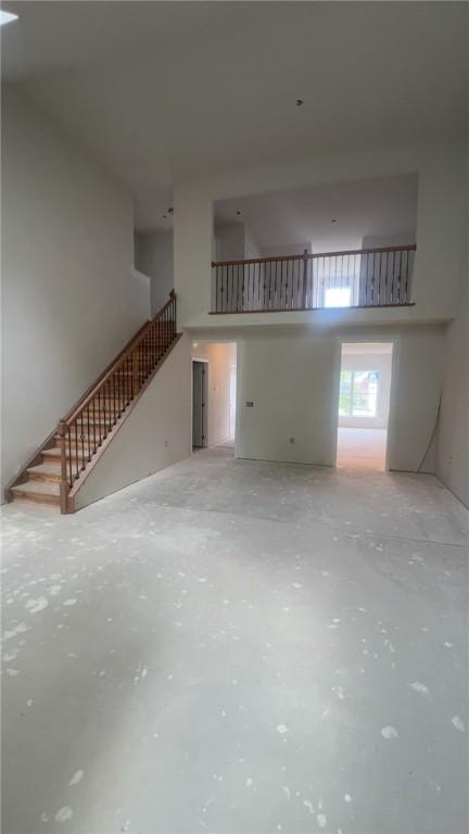 149 Shady River Blvd Unit 40B, Economy, PA 15005 - unfurnished living room with a towering ceiling, concrete flooring, and stairway