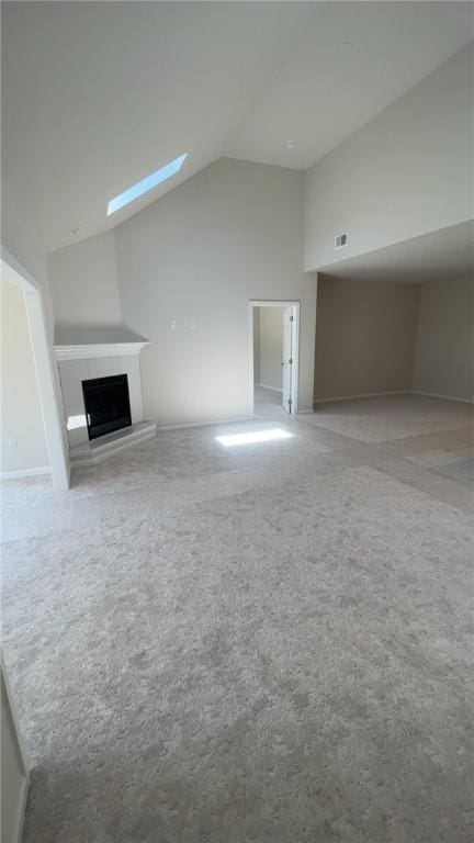 149 Shady River Blvd Unit 40B, Economy, PA 15005 - unfurnished living room featuring carpet flooring, a skylight, a fireplace with raised hearth, and high vaulted ceiling