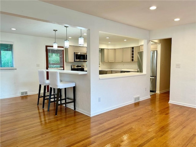 622 Fuhrman Ln, Buffalo Twp But, PA 16229 - kitchen featuring appliances with stainless steel finishes, decorative backsplash, light wood-type flooring, a breakfast bar, and recessed lighting
