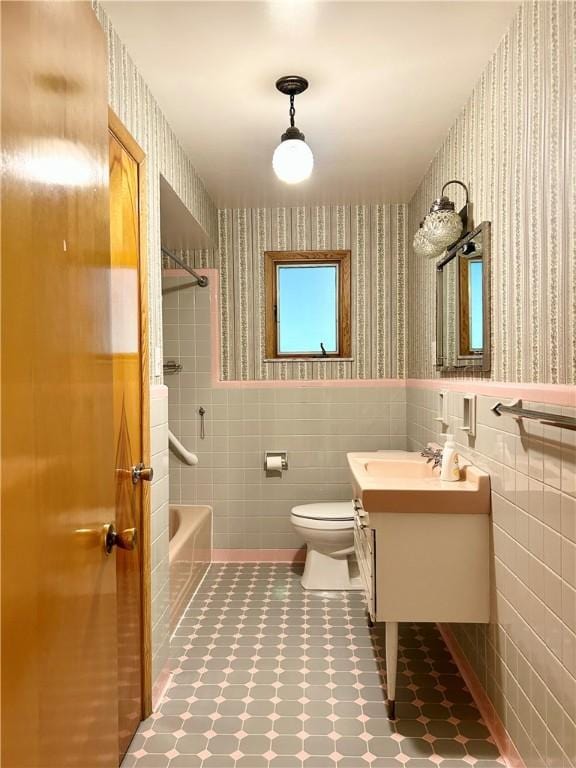 622 Fuhrman Ln, Buffalo Twp But, PA 16229 - bathroom with wallpapered walls, vanity, tile walls, wainscoting, and shower / bathtub combination