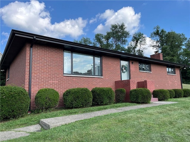 622 Fuhrman Ln, Buffalo Twp, PA 16229 - view of front of home featuring brick siding, a front lawn, and a chimney