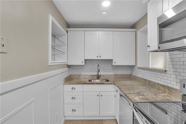 354 Ryan Dr, Pittsburgh, PA 15220 - kitchen with stainless steel appliances, white cabinetry, open shelves, light stone counters, and tasteful backsplash