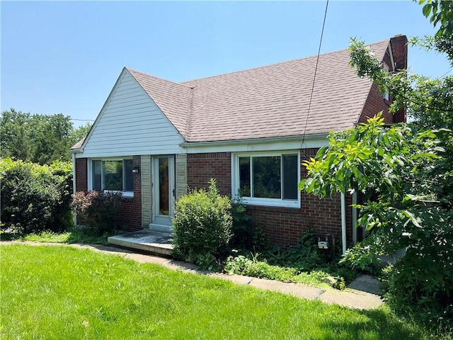 238 Humphrey Rd, Hempfield Twp Wml, PA 15601 - view of front of property featuring brick siding, a chimney, a front lawn, and a shingled roof