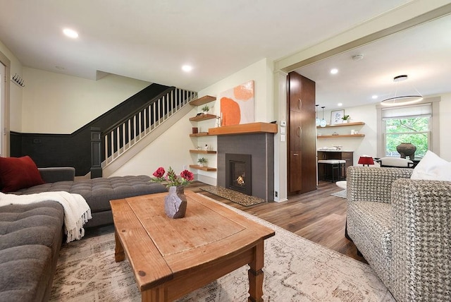 206 Lincoln Ave, Edgewood, PA 15218 - living room with stairs, light wood-style flooring, a warm lit fireplace, and recessed lighting