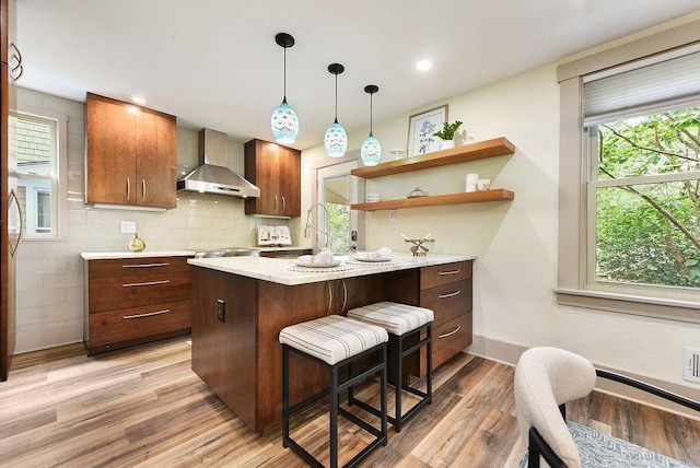 206 Lincoln Ave, Edgewood, PA 15218 - kitchen with wall chimney range hood, light countertops, light wood-type flooring, a kitchen bar, and open shelves