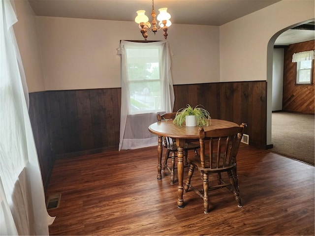 1025 Union Ave, Brackenridge, PA 15014 - dining room featuring a wainscoted wall, arched walkways, wood walls, a chandelier, and wood finished floors