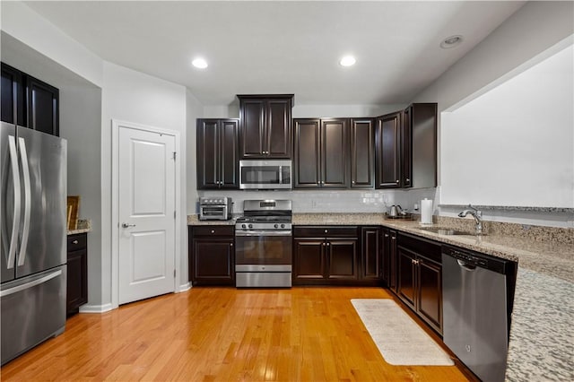 265 Sunrise Dr, Collier Twp, PA 15106 - kitchen featuring appliances with stainless steel finishes, light wood-style floors, light stone counters, tasteful backsplash, and recessed lighting