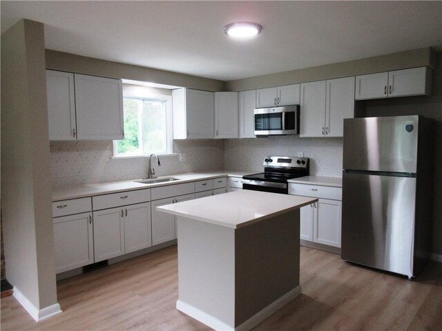 552 Heinz Camp Rd, Perry Twp Law, PA 16051 - kitchen with stainless steel appliances, light wood-style floors, tasteful backsplash, light countertops, and a kitchen island
