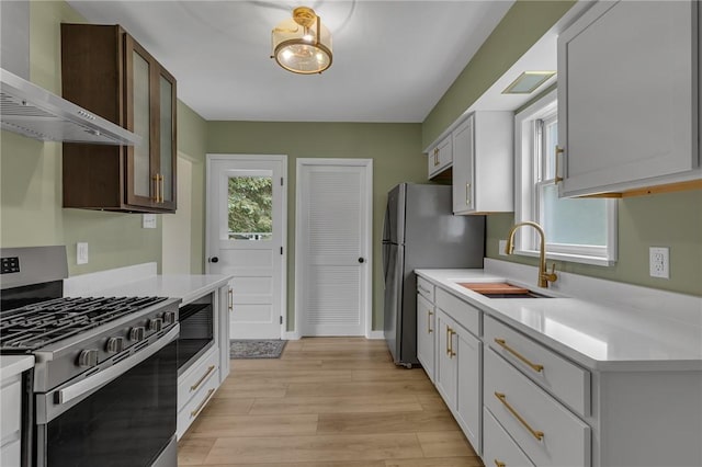 452 Canal St, Beaver, PA 15009 - kitchen with stainless steel appliances, wall chimney exhaust hood, light countertops, and light wood-type flooring