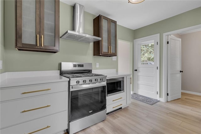 452 Canal St, Beaver, PA 15009 - kitchen featuring wall chimney exhaust hood, stainless steel appliances, dark brown cabinets, light countertops, and light wood-style floors