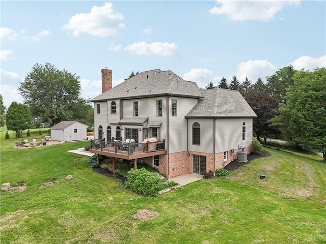 108 Ascot Ct, Lancaster Twp, PA 16037 - back of property with a deck, a chimney, a lawn, a storage unit, and roof with shingles