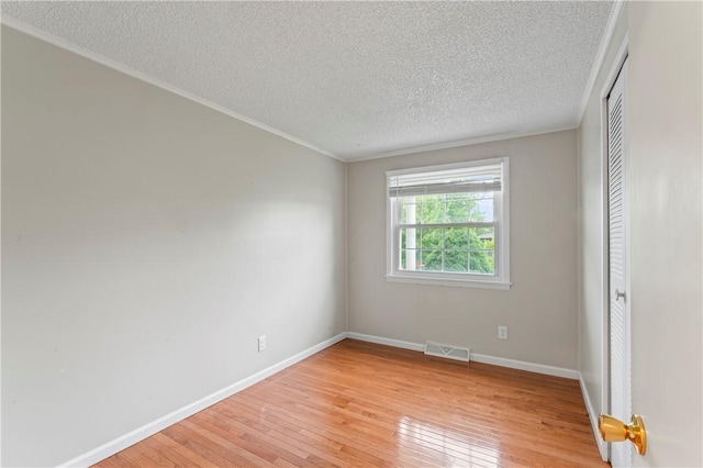 1032 Grove St, Monaca, PA 15061 - spare room featuring light wood-type flooring, a textured ceiling, and crown molding