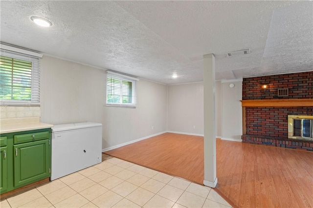 1032 Grove St, Monaca, PA 15061 - basement featuring a textured ceiling, fridge, light wood-type flooring, and a fireplace