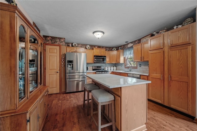 321 Dairy Farm Rd, Allegheny Twp Wml, PA 15068 - kitchen featuring appliances with stainless steel finishes, wood finished floors, light countertops, a breakfast bar, and a center island