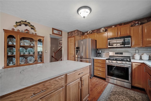 321 Dairy Farm Rd, Allegheny Twp Wml, PA 15068 - kitchen with appliances with stainless steel finishes, light wood-style floors, brown cabinetry, and tasteful backsplash