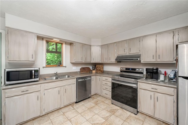 202 Village Ln, New Wilmington Boro, PA 16142 - kitchen featuring stainless steel appliances, under cabinet range hood, light countertops, a textured ceiling, and light tile patterned flooring