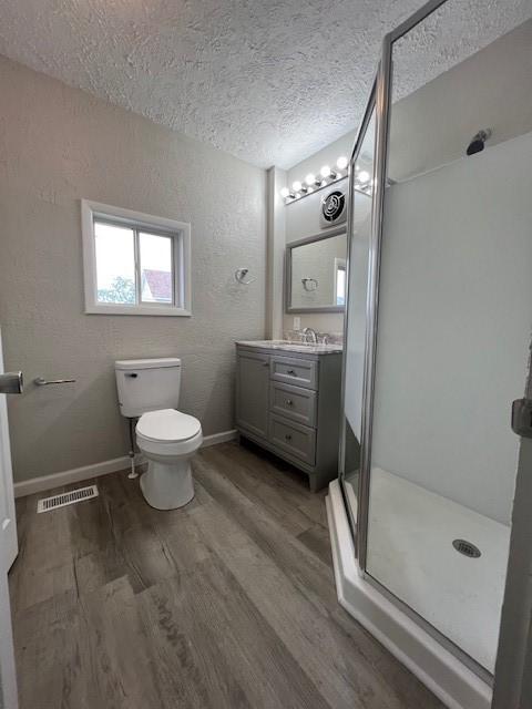819 Forest St, Latrobe, PA 15650 - full bath with a shower stall, wood finished floors, vanity, and a textured ceiling