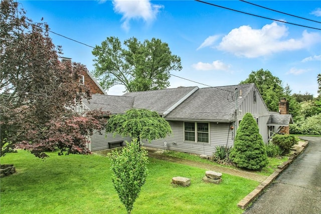 570 S 7th St, Sharpsville, PA 16150 - view of side of home with a lawn, a shingled roof, and board and batten siding