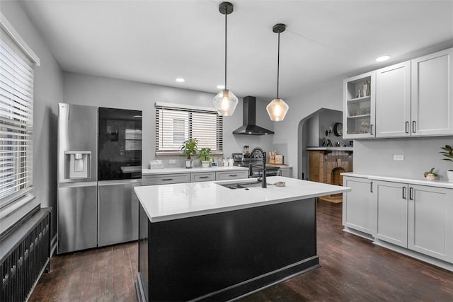 171 Clearview Ave, Ross Twp, PA 15229 - kitchen with wall chimney range hood, stainless steel refrigerator with ice dispenser, radiator heating unit, light countertops, and arched walkways