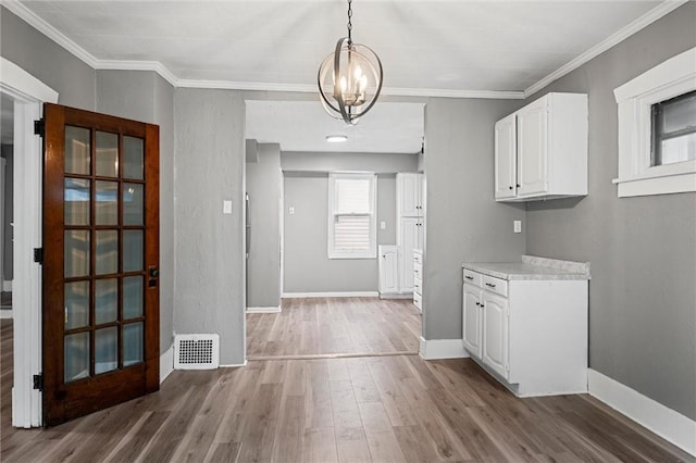 1204 Griswold St, Sharon, PA 16146 - kitchen featuring a chandelier, wood finished floors, light countertops, white cabinets, and ornamental molding