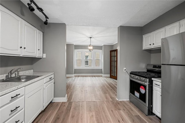 1204 Griswold St, Sharon, PA 16146 - kitchen with stainless steel appliances, white cabinetry, light countertops, light wood-style flooring, and a textured ceiling