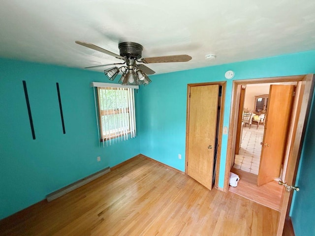 717 King St, Mckeesport, PA 15132 - unfurnished bedroom with baseboard heating, wood finished floors, and a ceiling fan
