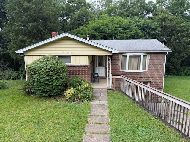 717 King St, Mckeesport, PA 15132 - view of front facade with brick siding, a front lawn, covered porch, and a chimney