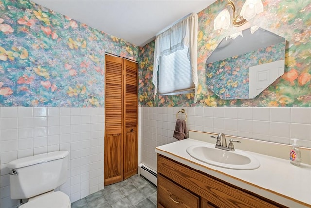373 Copperfield Ave, Carrick, PA 15210 - bathroom with wallpapered walls, a baseboard heating unit, tile walls, vanity, and wainscoting