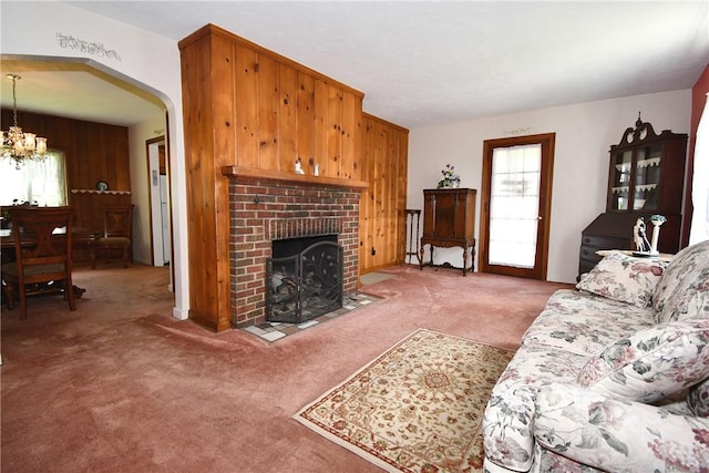 1673 Elderslee Rd, Baldwin Boro, PA 15227 - carpeted living area featuring a chandelier, a fireplace, arched walkways, and wood walls