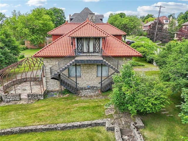 221 E Moody Ave, New Castle/2Nd, PA 16101 - back of house with stairway, stone siding, a tiled roof, and a lawn