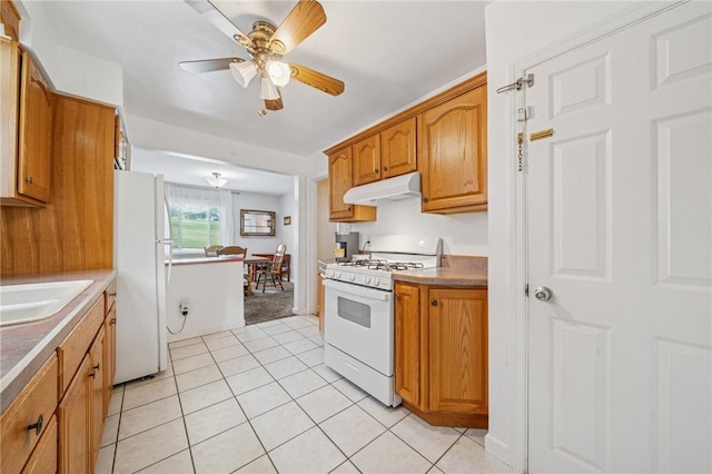 3176 Churchview Ave, Baldwin Boro, PA 15227 - kitchen featuring white appliances, under cabinet range hood, a ceiling fan, light tile patterned flooring, and brown cabinets