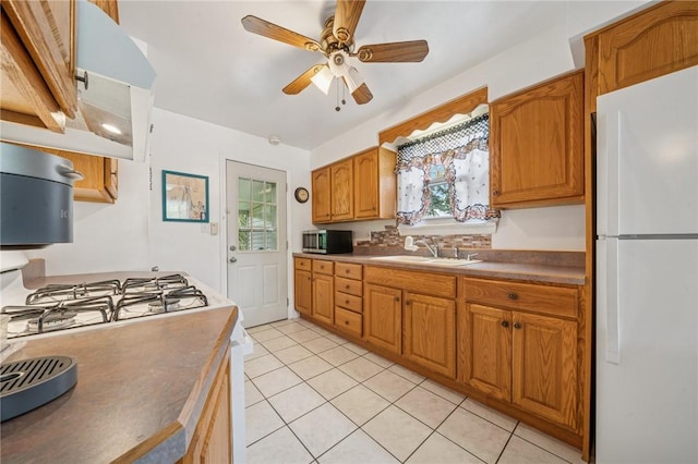3176 Churchview Ave, Baldwin Boro, PA 15227 - kitchen with freestanding refrigerator, stainless steel microwave, a ceiling fan, light tile patterned floors, and brown cabinetry