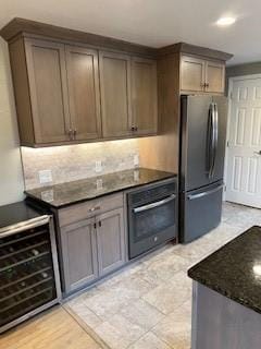 77 Ridgecrest Dr, Wilkins Twp, PA 15235 - kitchen with freestanding refrigerator, black oven, beverage cooler, and dark stone countertops