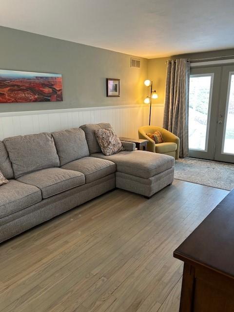 77 Ridgecrest Dr, Wilkins Twp, PA 15235 - living area featuring wainscoting, french doors, and light wood-style floors