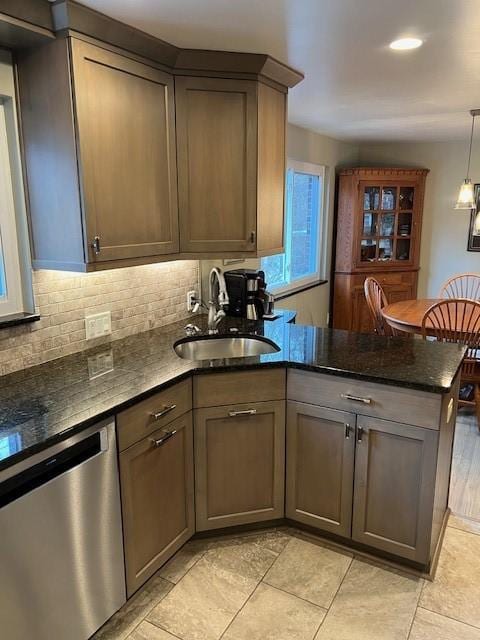 77 Ridgecrest Dr, Wilkins Twp, PA 15235 - kitchen featuring stainless steel dishwasher, a peninsula, backsplash, dark stone countertops, and hanging light fixtures