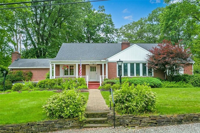 126 Elm Dr, Level Green, PA 15085 - view of front facade with a chimney, brick siding, a porch, and a front yard
