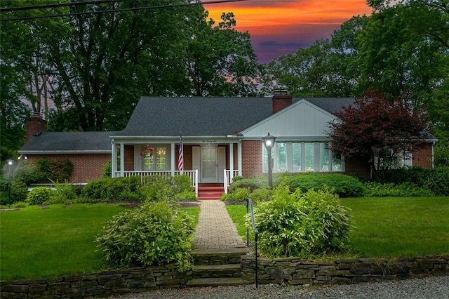 126 Elm Dr, Level Green, PA 15085 - view of front of home with a chimney, brick siding, a porch, and a yard