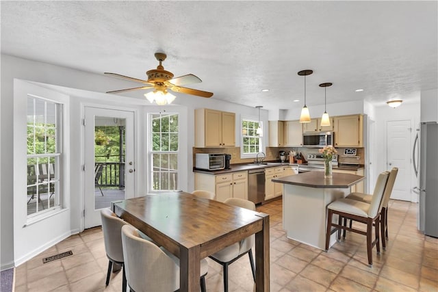 406 Pin Oak Ct, Coraopolis, PA 15108 - kitchen with appliances with stainless steel finishes, dark countertops, backsplash, a ceiling fan, and a kitchen island