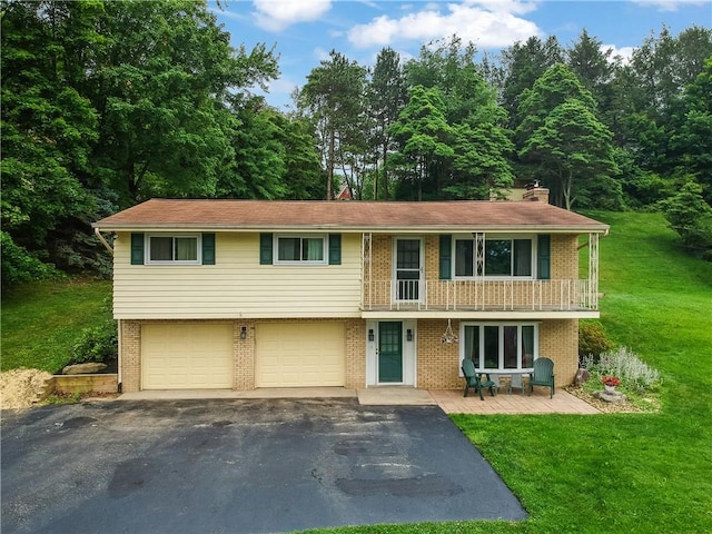 156 Dwellington Dr, Middlesex Twp, PA 16059 - view of front facade with asphalt driveway, a balcony, brick siding, a front yard, and an attached garage