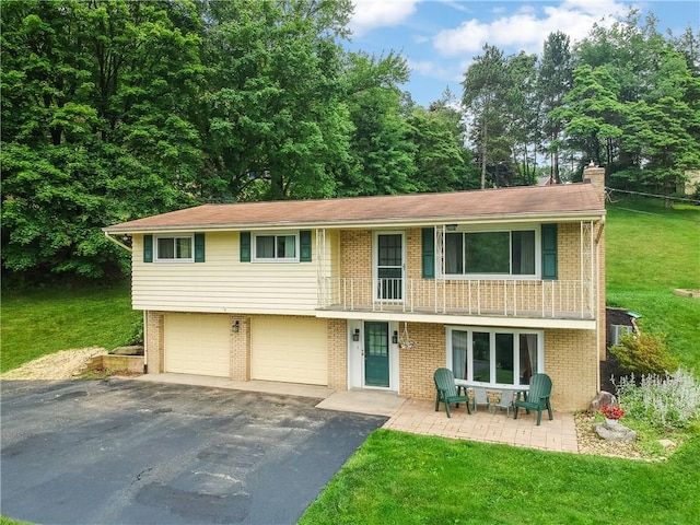 156 Dwellington Dr, Middlesex Twp, PA 16059 - view of front of house featuring asphalt driveway, a front yard, a balcony, a garage, and brick siding