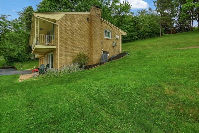 156 Dwellington Dr, Middlesex Twp, PA 16059 - view of home's exterior featuring a balcony, brick siding, a lawn, and a chimney