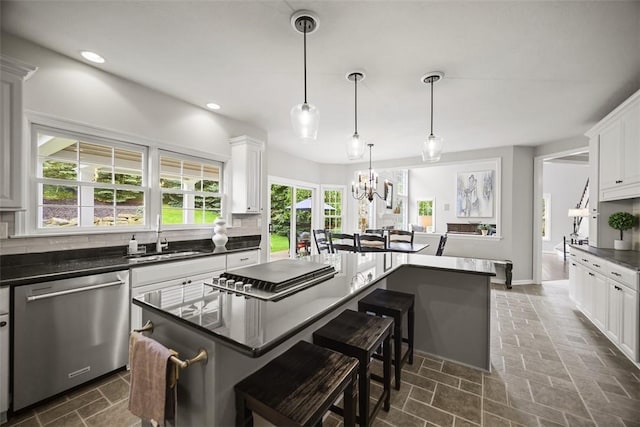 140 Golfview Dr, Adams Twp, PA 15044 - kitchen featuring stainless steel dishwasher, dark countertops, a kitchen breakfast bar, tasteful backsplash, and white cabinetry