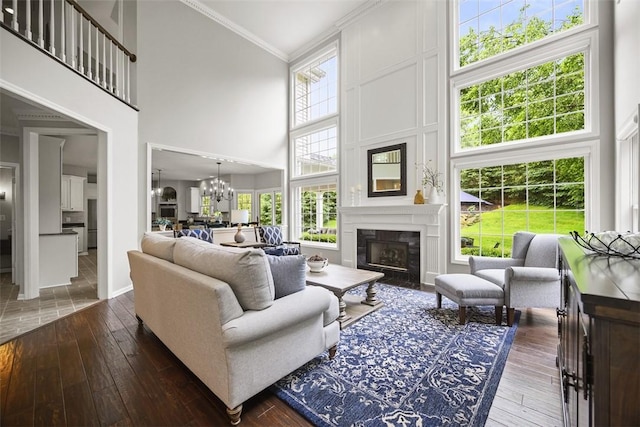 140 Golfview Dr, Adams Twp, PA 15044 - living area with a towering ceiling, a chandelier, dark wood-type flooring, crown molding, and a premium fireplace
